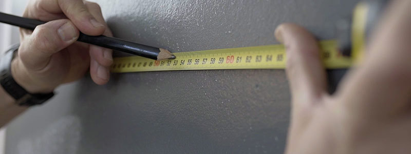 Bredden på veggen måles og det lages markeringer for hver tapetbane